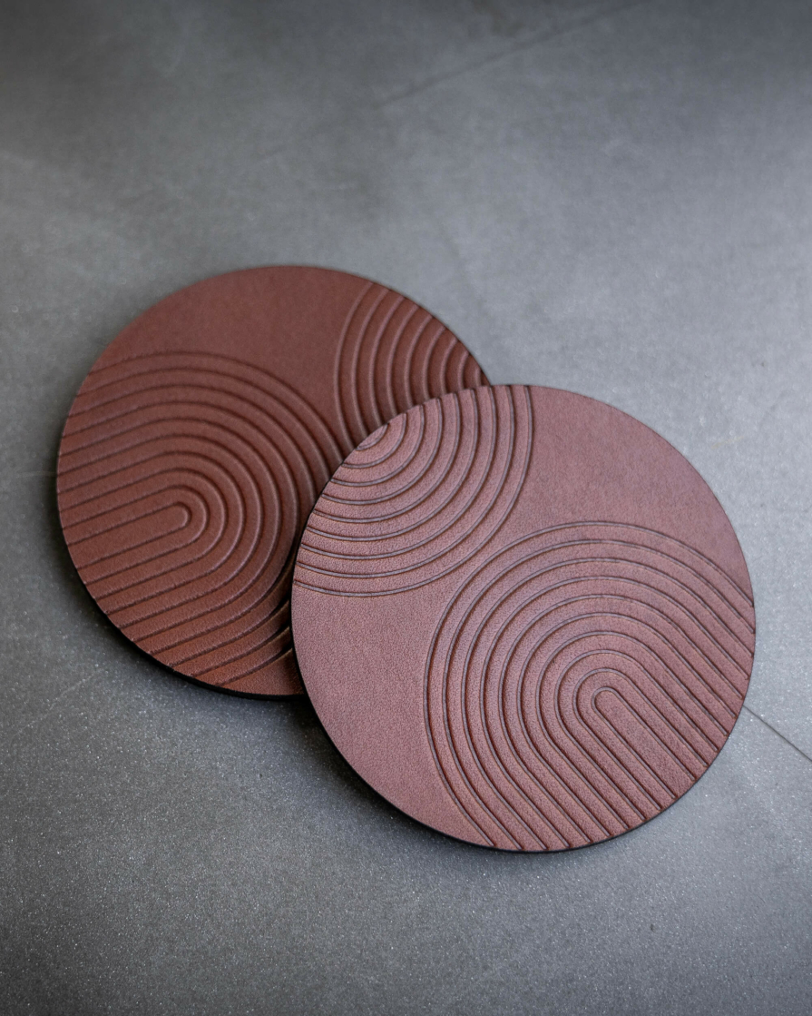 Brown leather coasters featuring modern arch pattern debossed on the surface.