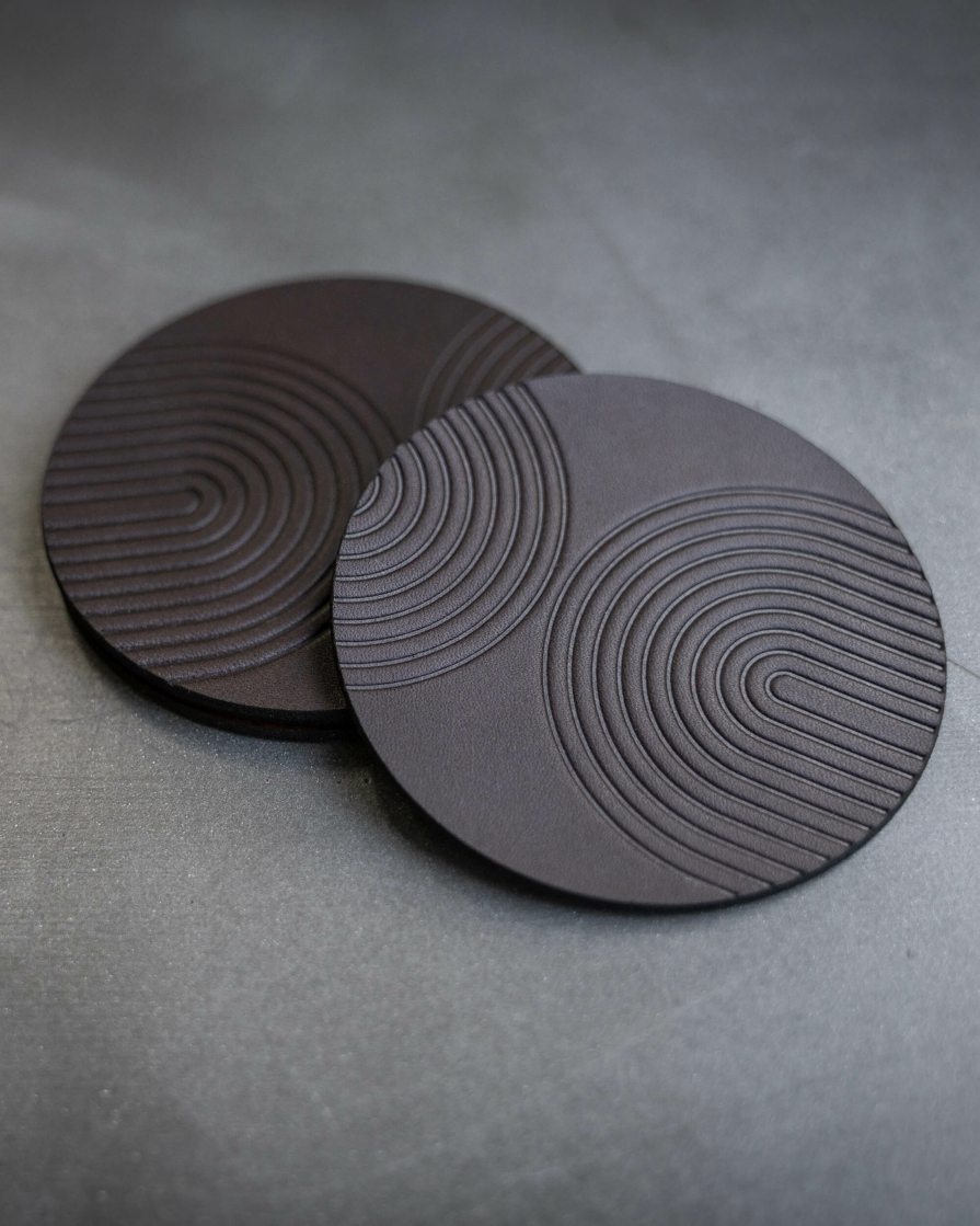 Dark Brown leather coasters featuring modern arch pattern debossed on the surface.