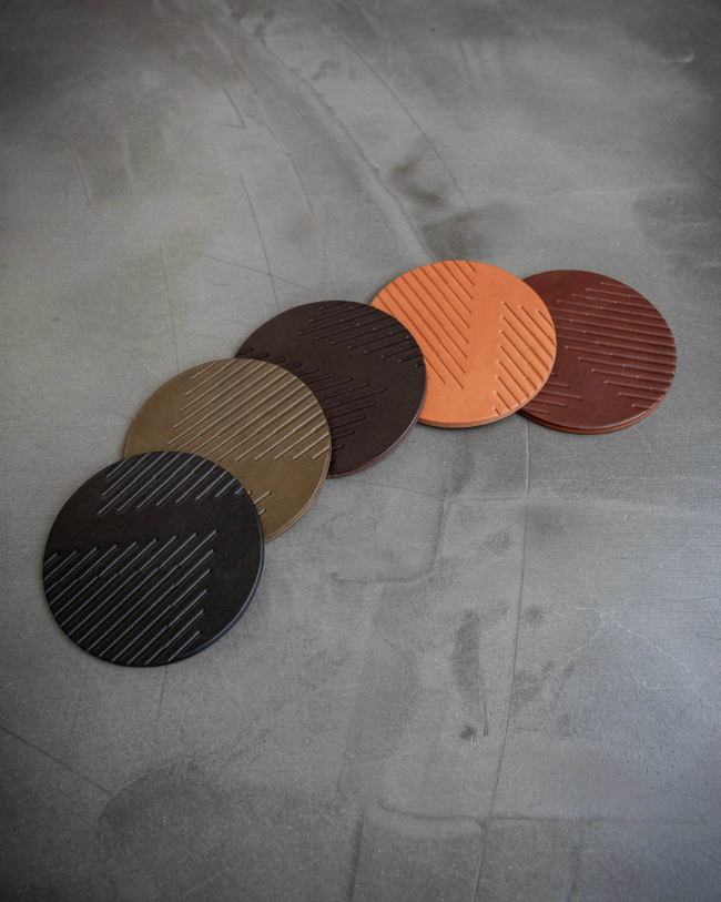 Multi colored leather coasters featuring modern stripe pattern debossed on the surface.